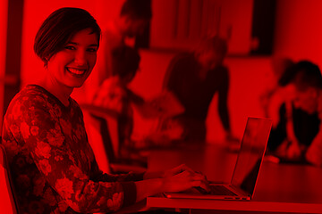 Image showing young business woman at office working on laptop with team on me