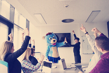 Image showing boss dresed as bear having fun with business people in trendy of