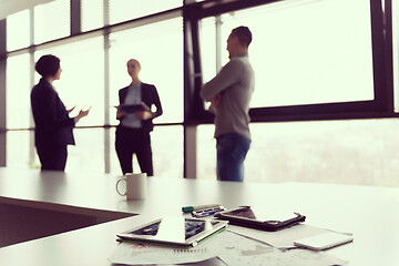 Image showing close up of tablet, business people on meeting in background