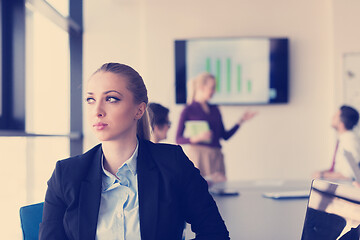 Image showing portrait of young business woman at office with team on meeting 