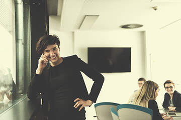 Image showing Elegant Woman Using Mobile Phone by window in office building