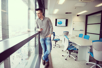 Image showing young business man using smart phone at office