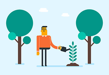 Image showing Young caucasian white gardener watering plant.