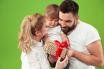 Image showing happy family with kid together and smiling at camera isolated on green