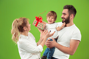 Image showing happy family with kid together and smiling at camera isolated on green