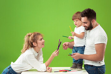 Image showing happy family with kid together and smiling at camera isolated on green