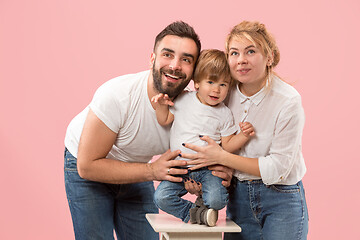 Image showing happy family with kid together and smiling at camera isolated on pink