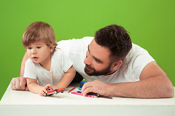 Image showing happy family with kid together and smiling at camera isolated on green