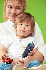 Image showing happy family with kid together and smiling at camera isolated on green