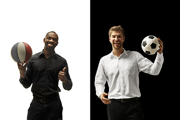 Image showing Portrait of a smiling men holding soccer and basketball ball isolated on a white and black background