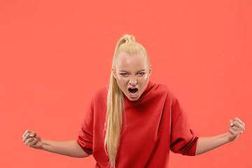 Image showing The young emotional angry woman screaming on coral studio background