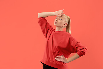 Image showing Beautiful woman looking suprised and bewildered isolated on coral