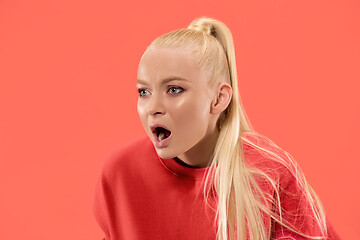 Image showing The young emotional angry woman screaming on coral studio background