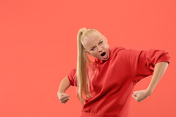 Image showing The young emotional angry woman screaming on coral studio background