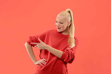 Image showing Isolated on coral young casual woman shouting at studio