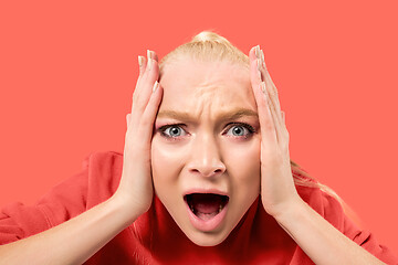 Image showing The young emotional angry woman screaming on coral studio background