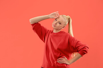 Image showing Beautiful woman looking suprised and bewildered isolated on coral