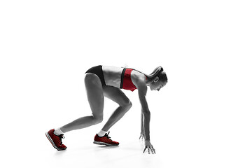 Image showing Portrait of young sporty woman at starting block of race isolated over white background