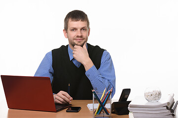 Image showing A confident man sits at the computer on a white background