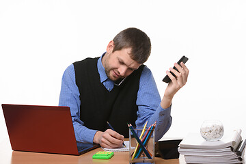 Image showing office worker records information received in a telephone conversation