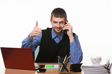 Image showing Manager talks on the phone with his thumb up