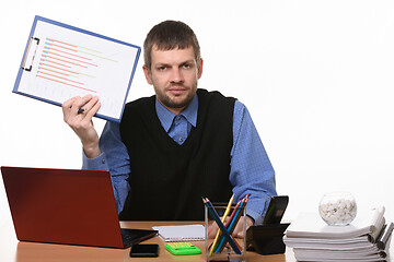 Image showing Office worker shows crossed out schedule sitting in the workplace