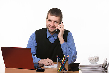 Image showing Entrepreneur talks on the phone at the desk on a white background