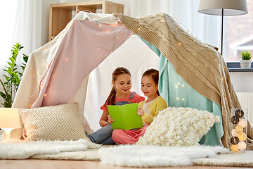 Image showing happy girls reading book in kids tent at home