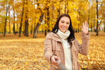 Image showing woman taking picture by selfiestick at autumn park