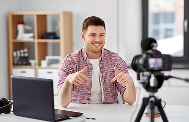 Image showing male blogger with camera videoblogging at home