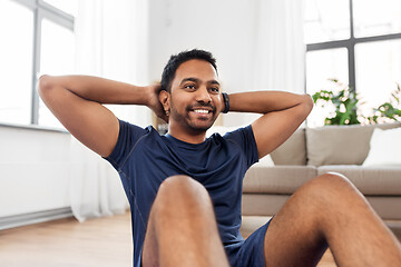 Image showing indian man making abdominal exercises at home