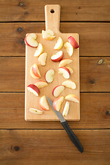 Image showing sliced apples and knife on wooden cutting board