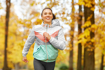 Image showing young woman running in autumn park