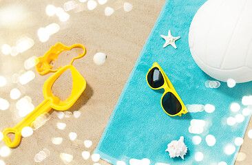 Image showing sunglasses, sand toys and ball on beach towel