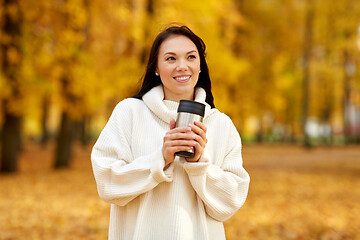 Image showing woman with hot drink in tumbler at autumn park