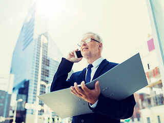 Image showing senior businessman calling on smartphone in city