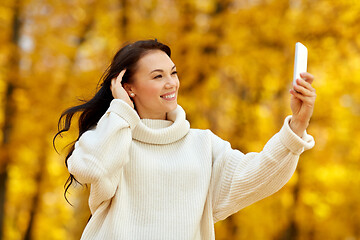 Image showing woman taking selfie by smartphone at autumn park