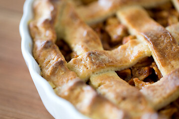 Image showing close up of apple pie in mold on wooden table