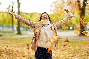 Image showing happy woman having fun with leaves in autumn park