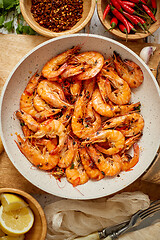 Image showing Roasted Prawns on frying pan served on white wooden cutting board