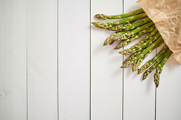 Image showing Fresh green asparagus in a brown paper bag. Healthy eating concept. Food for vegetarians