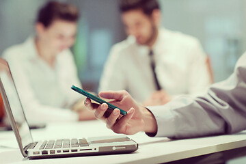 Image showing close up of  businessman hands  using smart phone on meeting