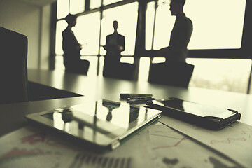 Image showing close up of tablet, business people on meeting in background