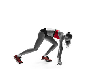 Image showing Portrait of young sporty woman at starting block of race isolated over white background