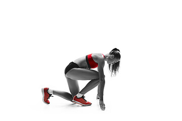 Image showing Portrait of young sporty woman at starting block of race isolated over white background