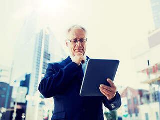 Image showing senior businessman with tablet pc on city street