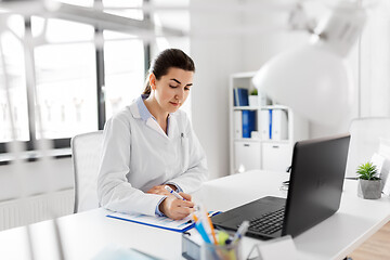 Image showing doctor with laptop and medical report at hospital