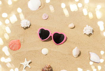 Image showing heart-shaped sunglasses and shells on beach sand