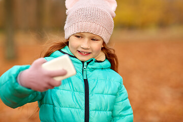 Image showing girl taking selfie by smartphone at autumn park