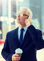 Image showing senior businessman calling on smartphone in city